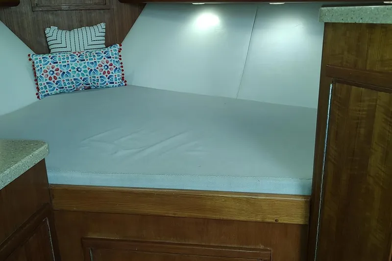 Never Enough Yacht Photos Pics 2017 Out Island SeaTek 36 Express cabin interior with bed and decorative pillows.