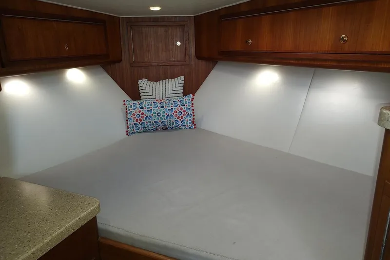 Never Enough Yacht Photos Pics 2017 Out Island SeaTek 36 Express cabin interior with cozy bed and decorative pillows.