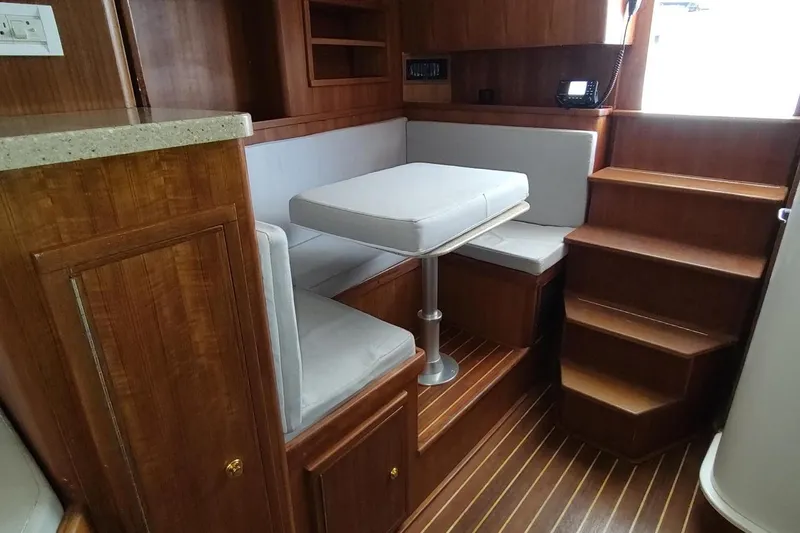 Never Enough Yacht Photos Pics 2017 Out Island SeaTek 36 Express interior with wooden cabinetry and cushioned seating.