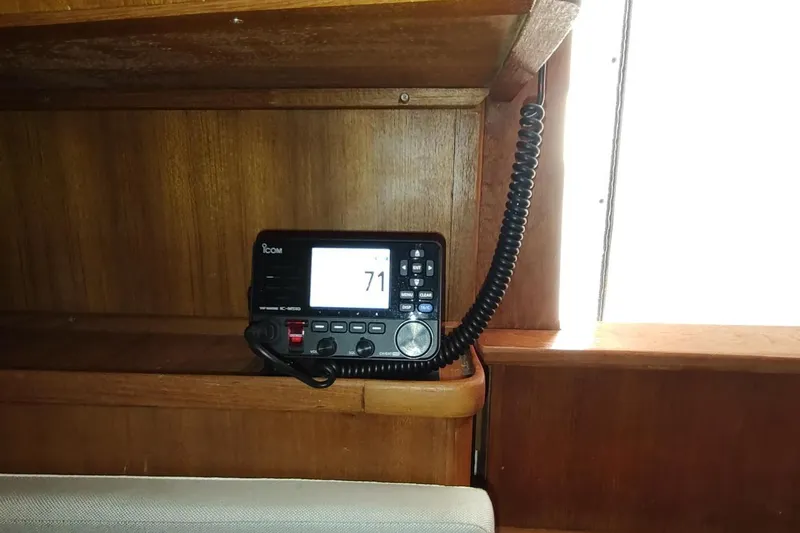 Never Enough Yacht Photos Pics Marine radio on 2017 Out Island SeaTek 36 Express boat, wooden interior.