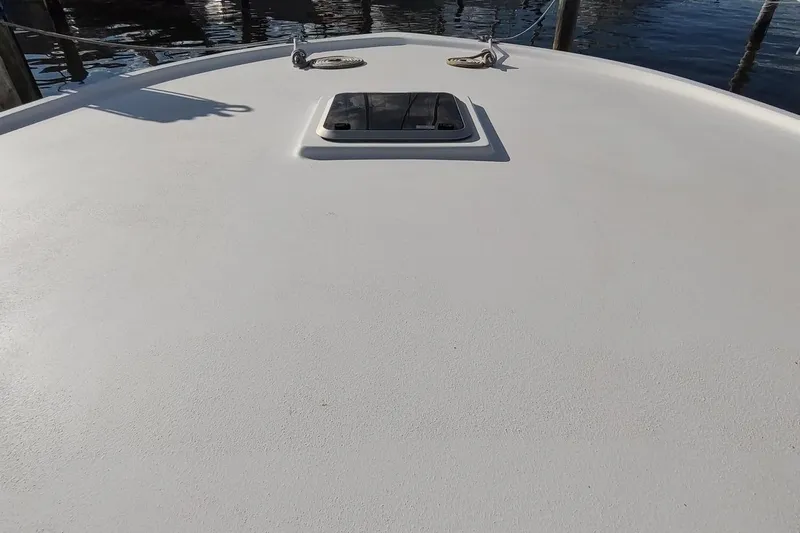 Never Enough Yacht Photos Pics 2017 Out Island SeaTek 36 Express boat deck with hatch, docked by the water.