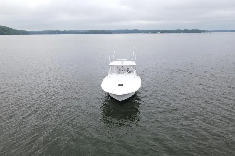 Never Enough Yacht Photos Pics 2017 Out Island SeaTek 36 Express boat on calm waters under cloudy sky.