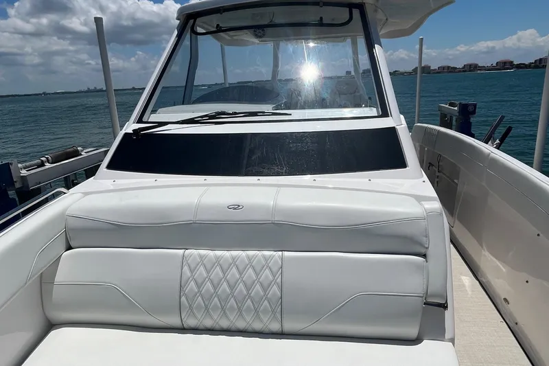  Yacht Photos Pics 2024 Regal 33 SAV boat with white seating, docked by the water.