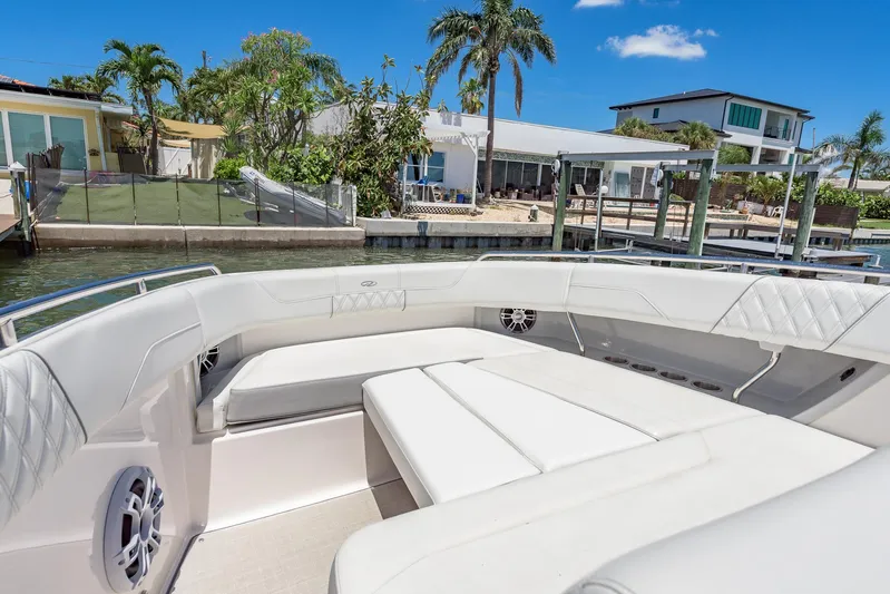  Yacht Photos Pics 2024 Regal 33 SAV boat interior with white seating, docked near waterfront homes.
