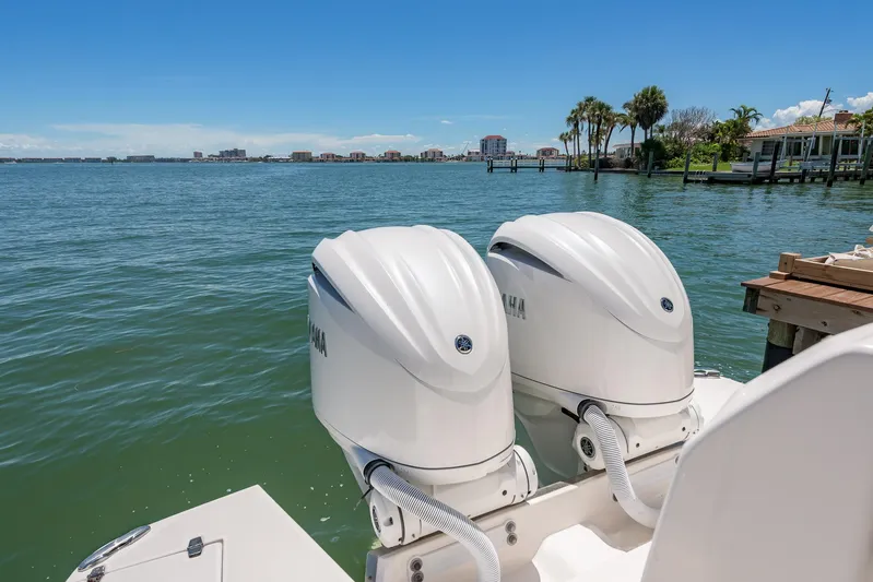  Yacht Photos Pics 2024 Regal 33 SAV boat with twin Yamaha outboard engines on a sunny waterfront.
