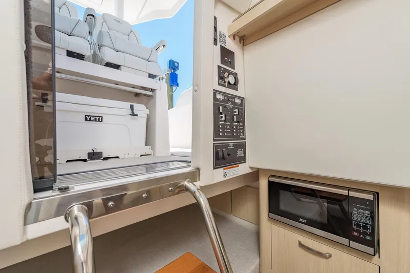  Yacht Photos Pics 2024 Regal 33 SAV interior with microwave, control panel, and Yeti cooler.