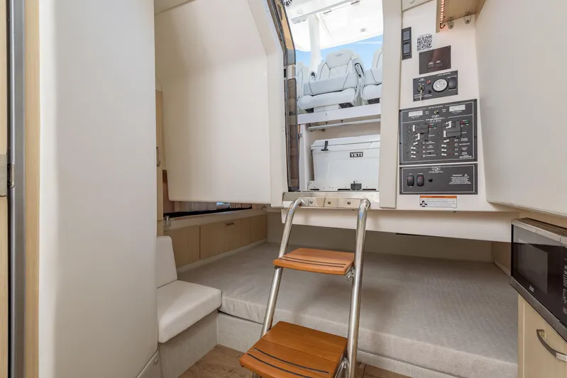  Yacht Photos Pics 2024 Regal 33 SAV interior cabin with ladder, control panel, and seating area.