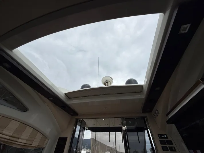  Yacht Photos Pics Interior view of 2011 Azimut 43S yacht with open sunroof and cloudy sky.