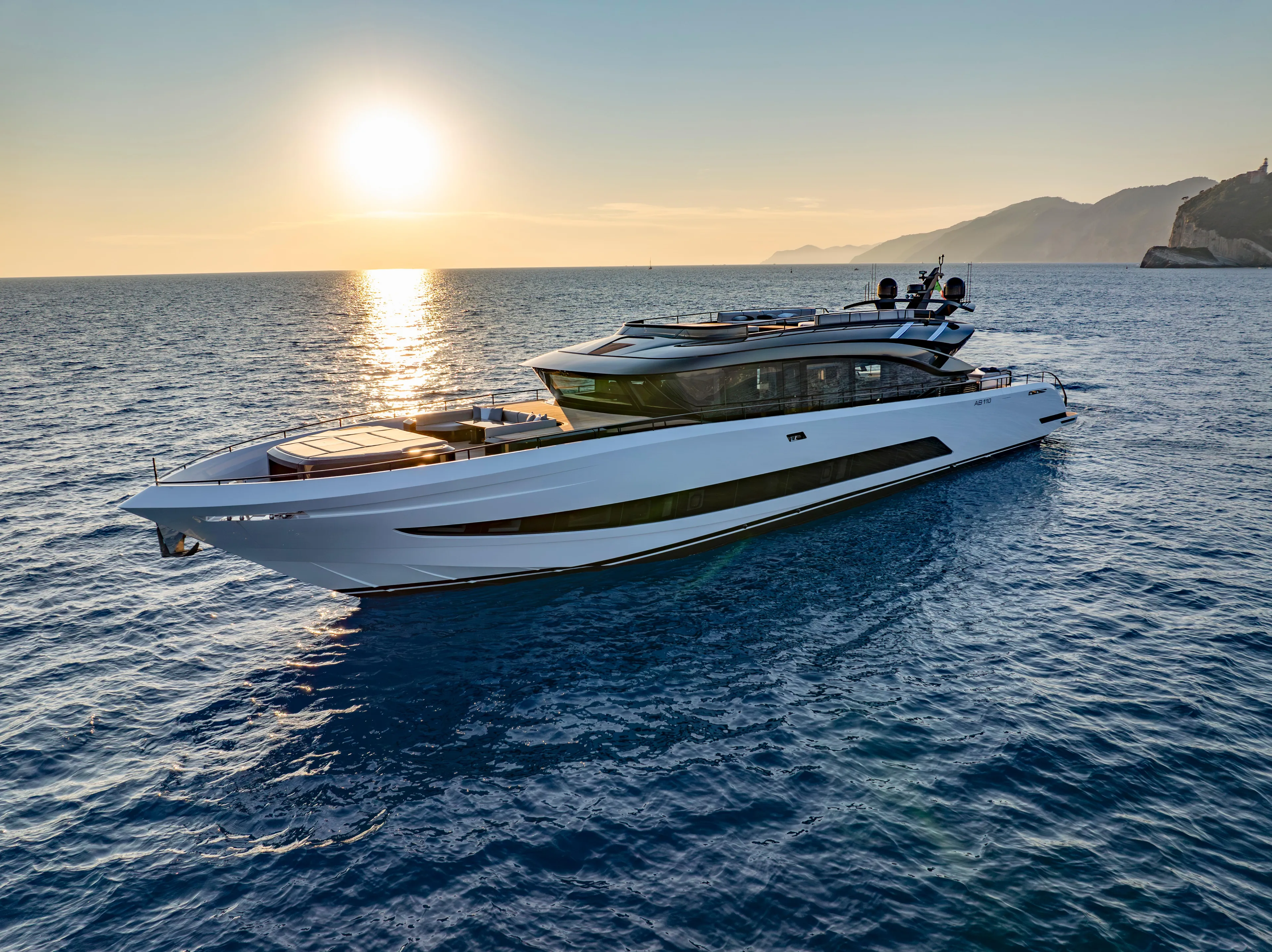 Luxurious 2026 AB 110 yacht cruising at sunset on serene ocean waters.