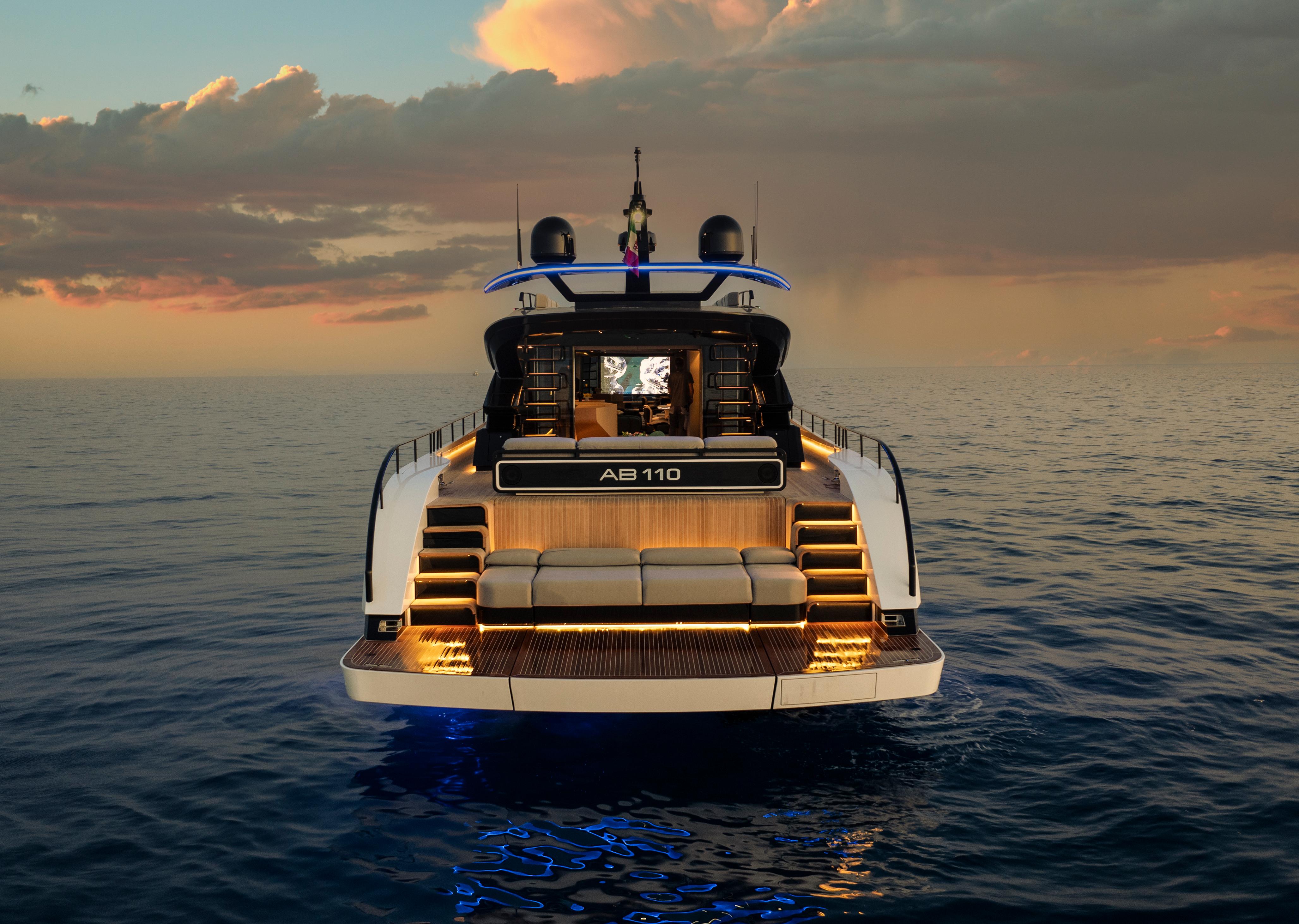 Luxury yacht AB 110, 2026 model, illuminated at sunset on open sea.