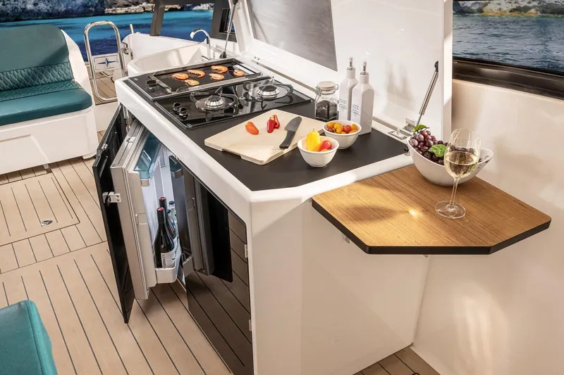 Inventory Clearance Yacht Photos Pics Modern kitchen on Bavaria Vida 33 yacht, featuring stove, fridge, and elegant dining setup.