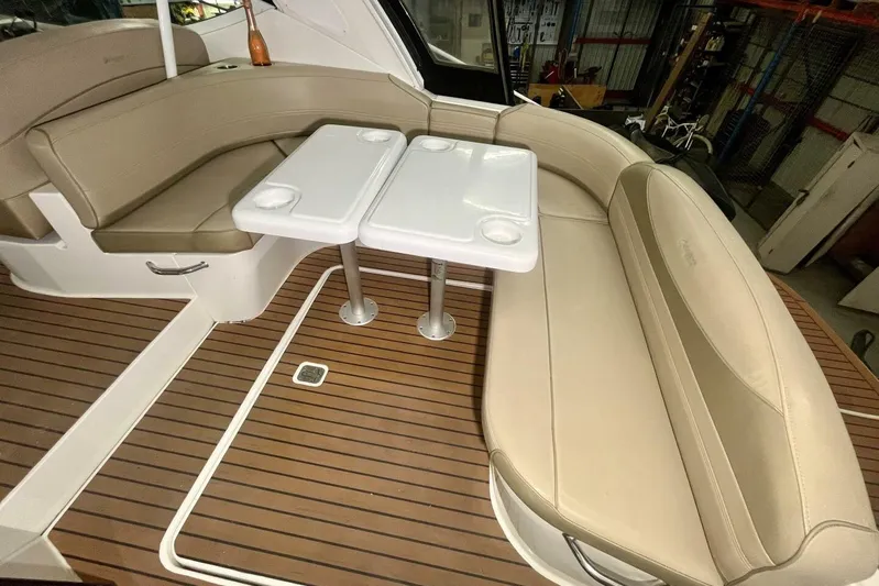 Yacht Photos Pics 2011 Cruisers Yachts 330 Express interior with beige seating and dual tables on wooden deck.