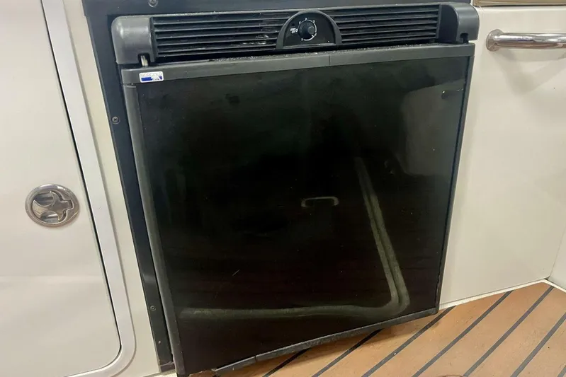  Yacht Photos Pics 2011 Cruisers Yachts 330 Express refrigerator, black door, wooden floor, interior view.