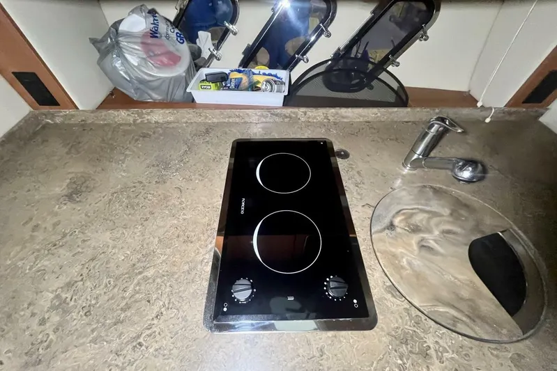  Yacht Photos Pics 2011 Cruisers Yachts 330 Express kitchen with stovetop and sink.