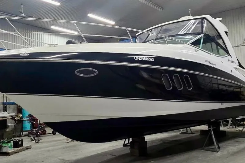  Yacht Photos Pics 2011 Cruisers Yachts 330 Express in a garage, sleek design, white and navy blue exterior.