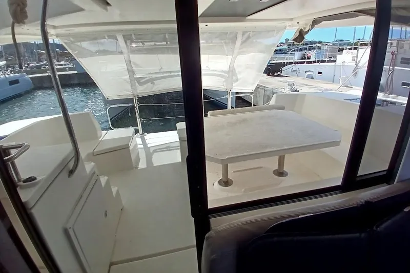 Mere Cat Yacht Photos Pics 2018 Leopard 45 yacht cockpit with table, seating, and marina view.