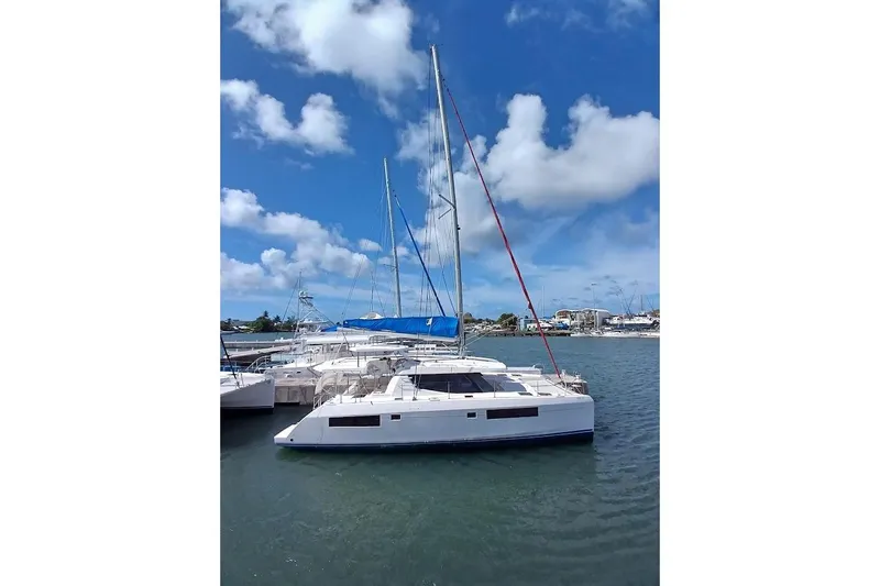 Mere Cat Yacht Photos Pics 2018 Leopard 45 catamaran docked in a sunny marina with blue skies.
