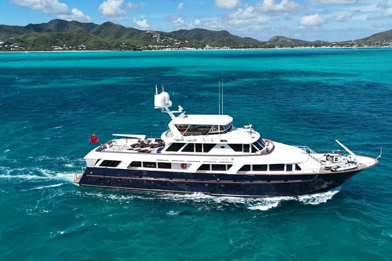 Flying Dutchman Yacht Photos Pics Luxurious 1984 Lloyds Ships Tri-Deck yacht cruising in turquoise waters near scenic coastline.