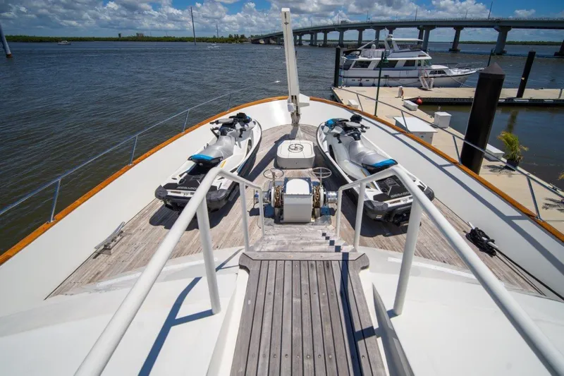 Flying Dutchman Yacht Photos Pics 1984 Lloyds Ships Tri-Deck yacht with jet skis on deck, docked near a bridge.