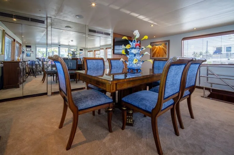Flying Dutchman Yacht Photos Pics Luxurious dining area on 1984 Lloyds Ships Tri-Deck yacht with elegant blue chairs.