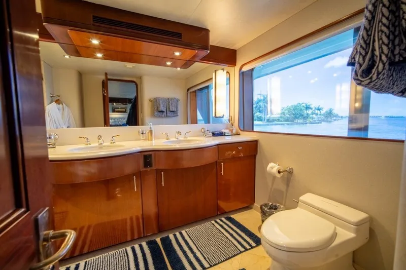 Flying Dutchman Yacht Photos Pics Luxurious yacht bathroom with dual sinks, large window, and elegant wood cabinetry on a 1984 Lloyds Ships Tri-Deck.