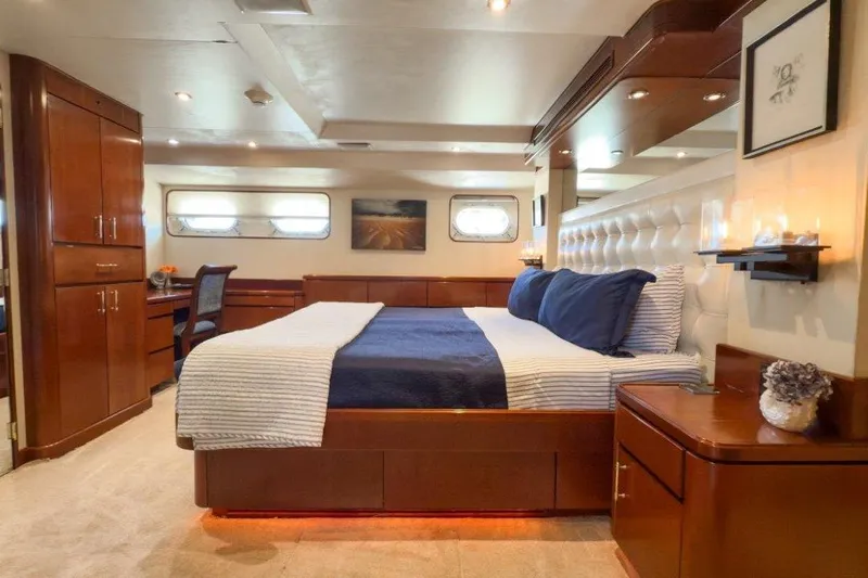 Flying Dutchman Yacht Photos Pics Luxurious bedroom interior on 1984 Lloyds Ships Tri-Deck yacht, featuring elegant wood furnishings.