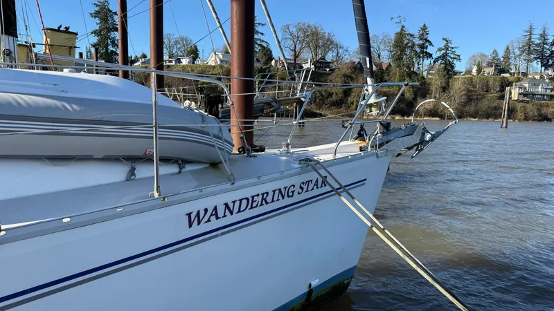  Yacht Photos Pics Catalina 470 sailboat named "Wandering Star" docked by a riverbank, 2004 model.