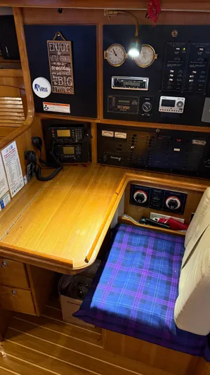  Yacht Photos Pics Navigation station of a 2004 Catalina 470 sailboat with control panels and seating.