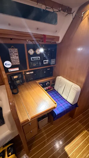  Yacht Photos Pics Navigation station inside 2004 Catalina 470 sailboat, featuring wooden desk and control panels.