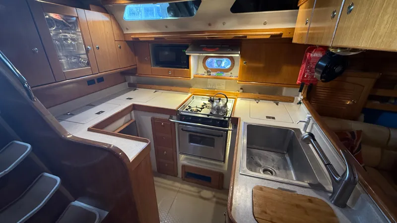  Yacht Photos Pics Galley kitchen in 2004 Catalina 470 yacht with stove, sink, and wooden cabinetry.