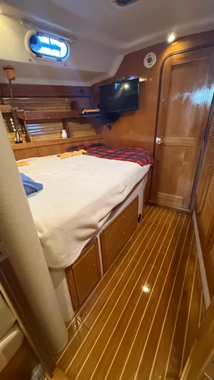  Yacht Photos Pics Catalina 470 yacht interior, 2004 model, featuring a cozy cabin with wood paneling and a bed.