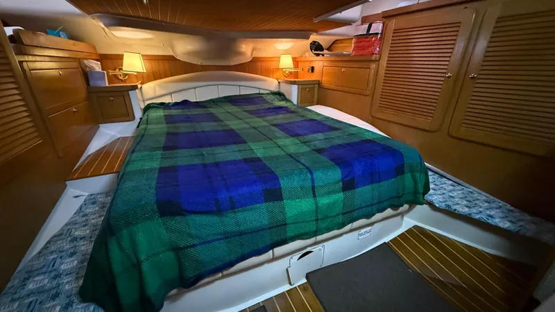  Yacht Photos Pics Cozy cabin interior of 2004 Catalina 470 yacht with plaid bedding and warm lighting.