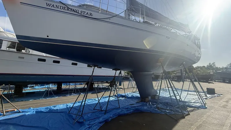  Yacht Photos Pics 2004 Catalina 470 sailboat "Wandering Star" on stands, sunlit in a boatyard.