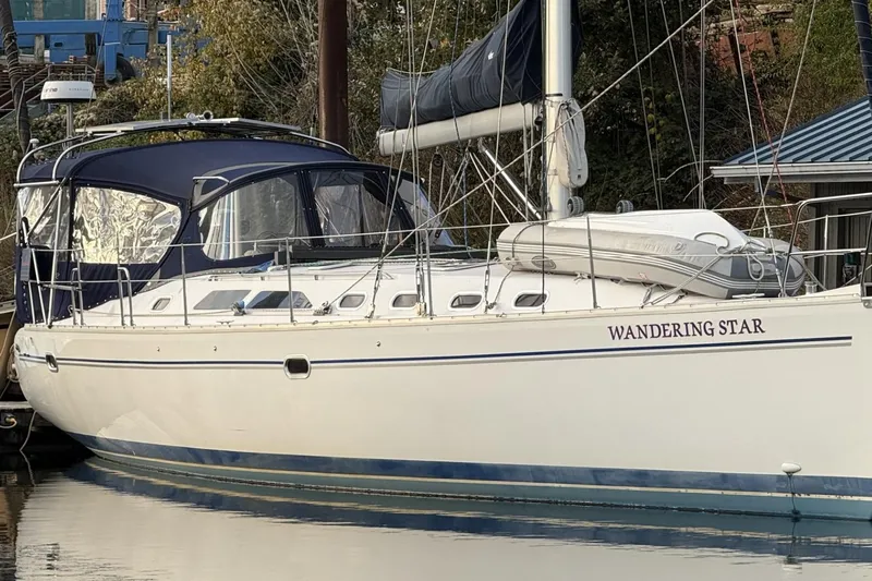  Yacht Photos Pics Catalina 470 sailboat named "Wandering Star" docked, 2004 model, with blue canopy.