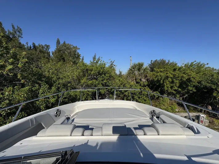  Yacht Photos Pics 2024 Sea Ray Sundancer 320 Outboard boat with spacious deck and lush greenery backdrop.