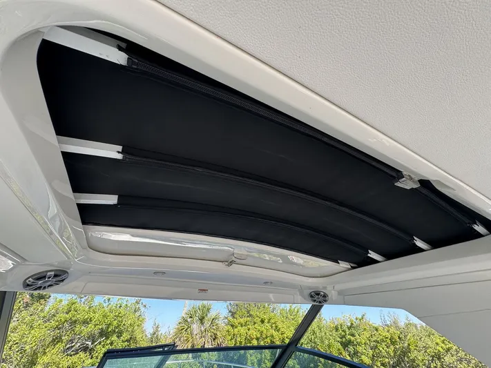  Yacht Photos Pics 2024 Sea Ray Sundancer 320 Outboard sunroof detail with lush greenery background.