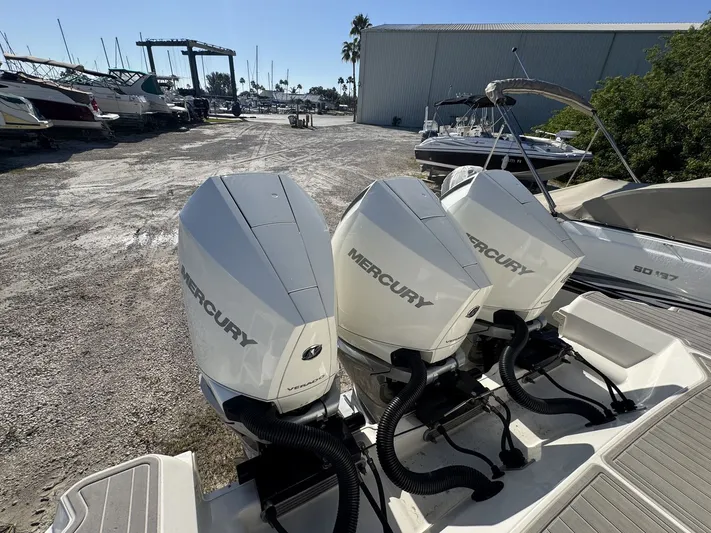  Yacht Photos Pics 2024 Sea Ray Sundancer 320 Outboard with triple Mercury engines in a marina setting.