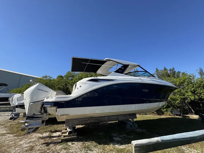  Yacht Photos Pics 2024 Sea Ray Sundancer 320 Outboard boat on display under clear blue sky.