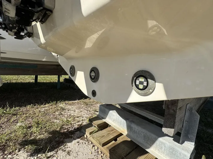  Yacht Photos Pics 2024 Sea Ray Sundancer 320 Outboard hull with underwater lights, displayed on a wooden stand.