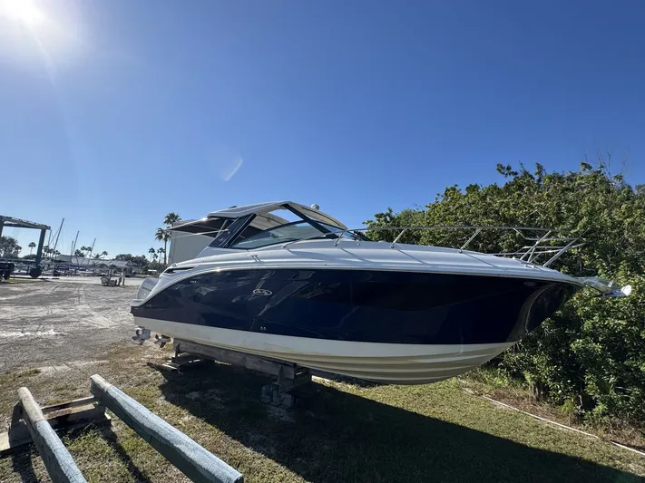  Yacht Photos Pics 2024 Sea Ray Sundancer 320 Outboard boat on land under clear blue sky.