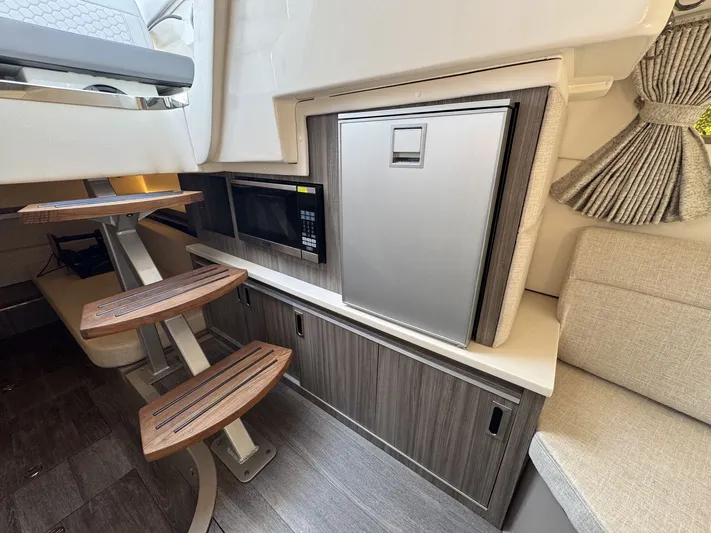  Yacht Photos Pics 2024 Sea Ray Sundancer 320 Outboard interior with microwave, fridge, and wooden steps.