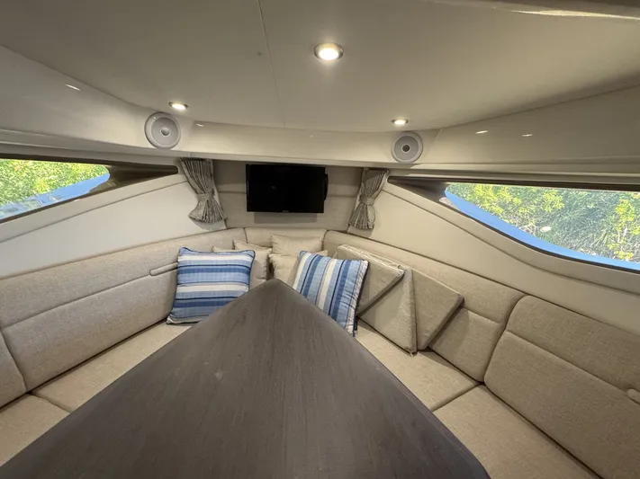  Yacht Photos Pics 2024 Sea Ray Sundancer 320 Outboard cabin interior with seating, cushions, and a TV.