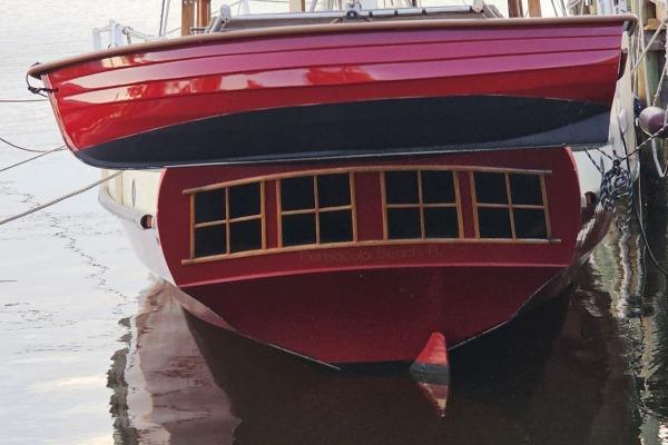 Red Parker Marine Lorcha 50 boat, 2002 model, docked on calm water.