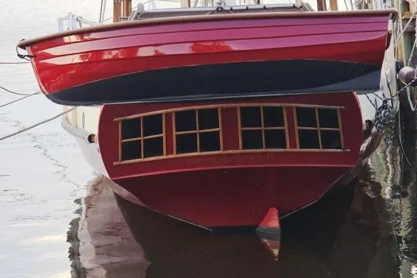 Red Parker Marine Lorcha 50 boat, 2002 model, docked on calm water.