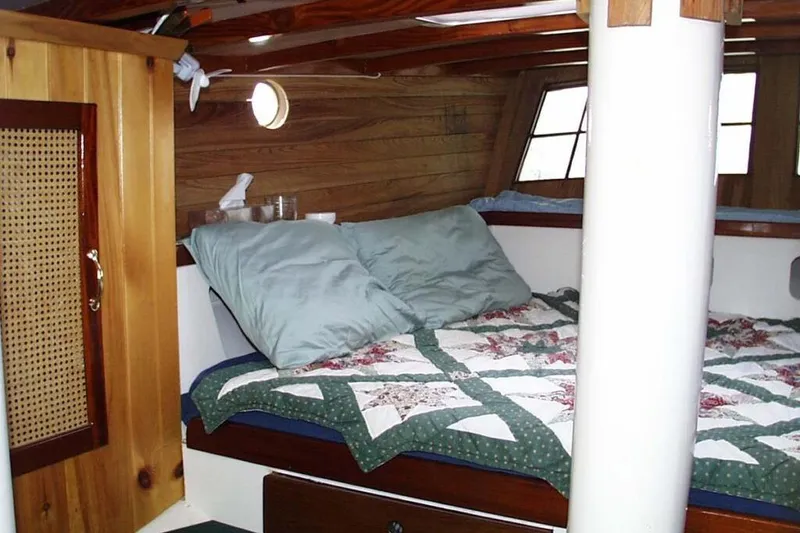 Tien Hou Yacht Photos Pics Cozy cabin interior of 2002 Parker Marine Lorcha 50 with quilted bedding and wooden accents.