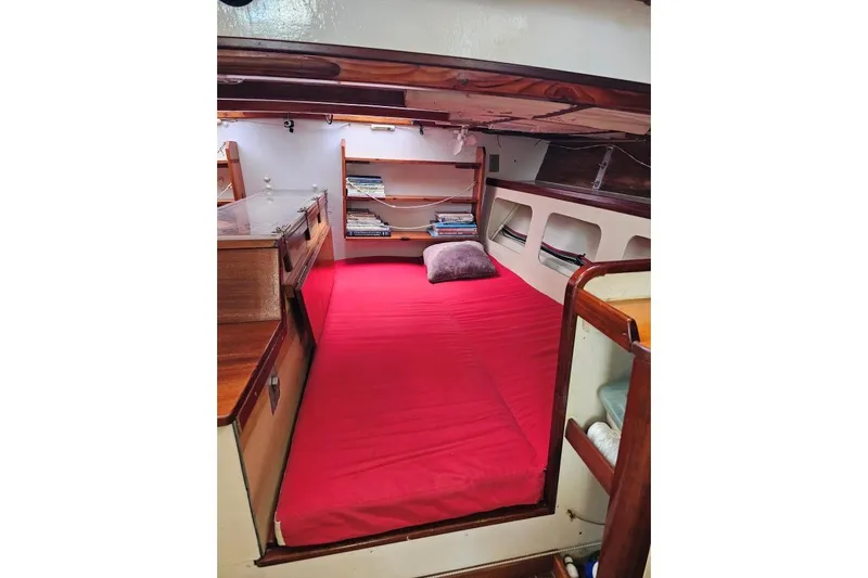 Tien Hou Yacht Photos Pics Cozy cabin interior of 2002 Parker Marine Lorcha 50 with red bedding and wooden shelves.