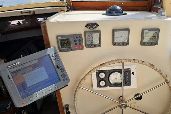 Tien Hou Yacht Photos Pics Control panel of 2002 Parker Marine Lorcha 50 with navigation instruments and steering wheel.