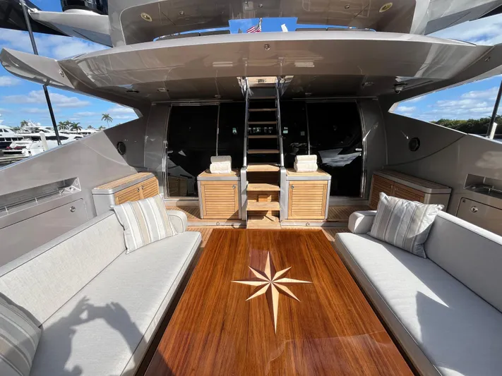 Izumi Yacht Photos Pics Luxurious Palmer Johnson 120 yacht deck with elegant seating and wooden table, 2008 model.