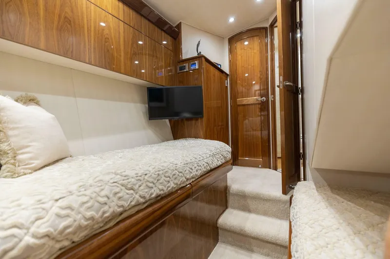 Da'grits Yacht Photos Pics Luxurious interior of 2018 Viking 62 Convertible yacht with cozy bedding and wooden finishes.