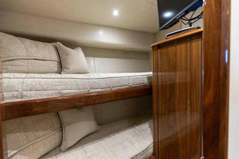 Da'grits Yacht Photos Pics Interior of 2018 Viking 62 Convertible yacht with cozy bunk beds and wooden cabinetry.